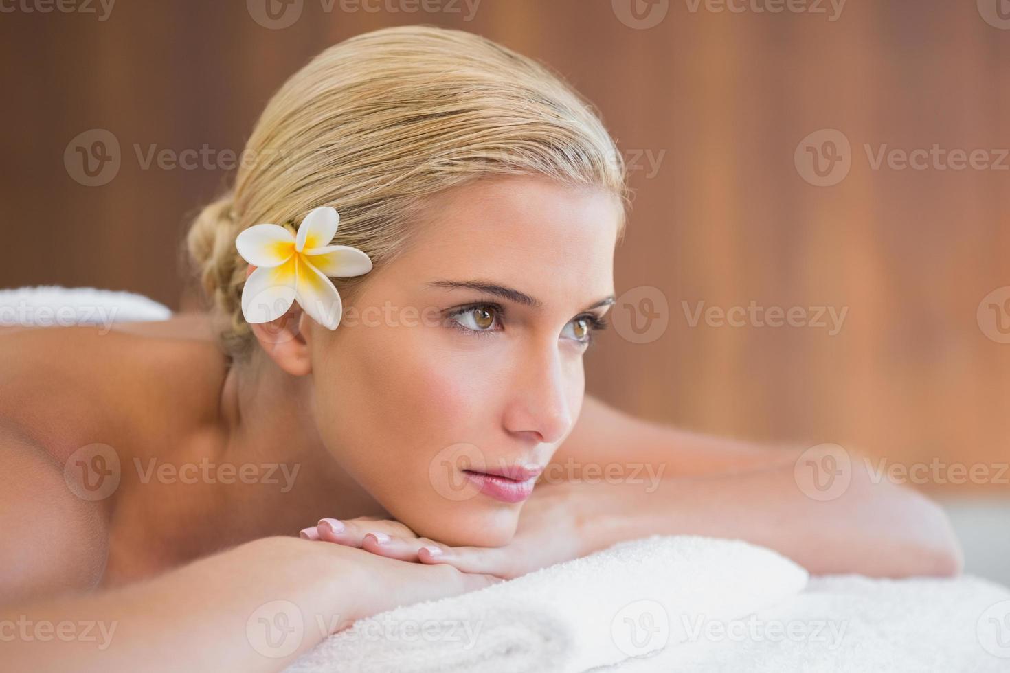 hermosa mujer acostada en la camilla de masaje en el spa center foto
