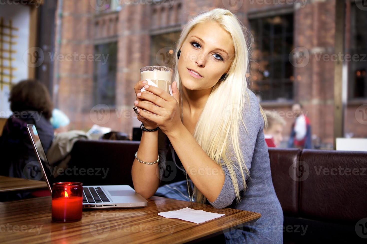 Young woman with laptop on cafe photo