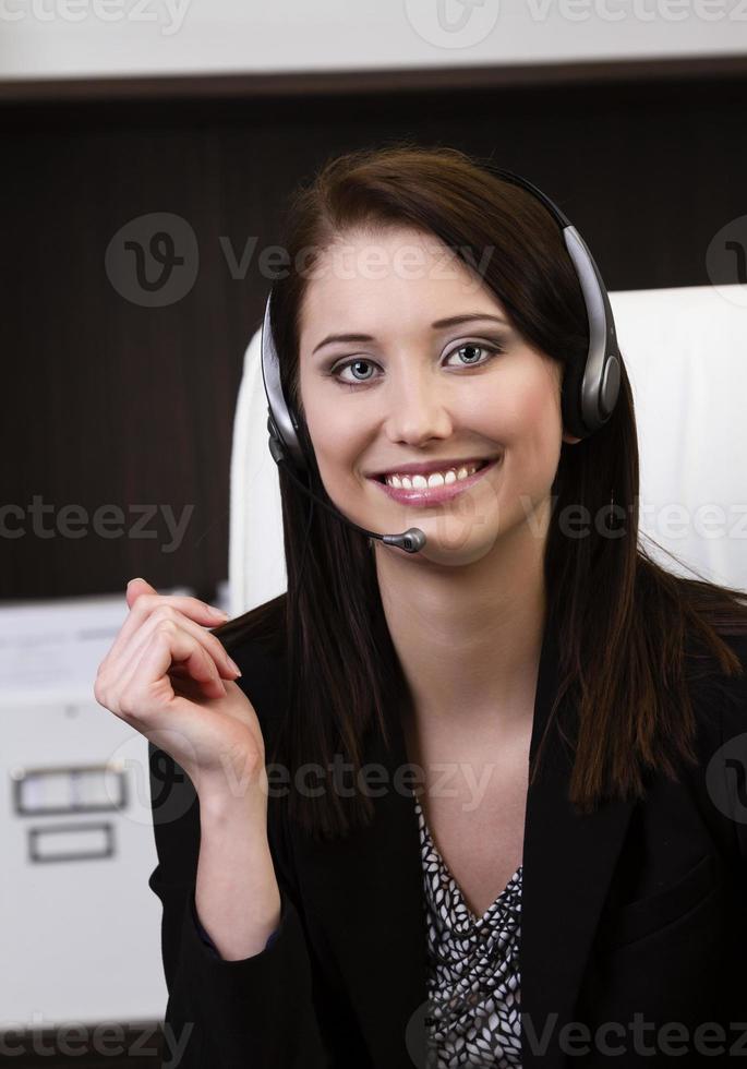 Primer plano de un empleado de call center femenino sonriendo foto