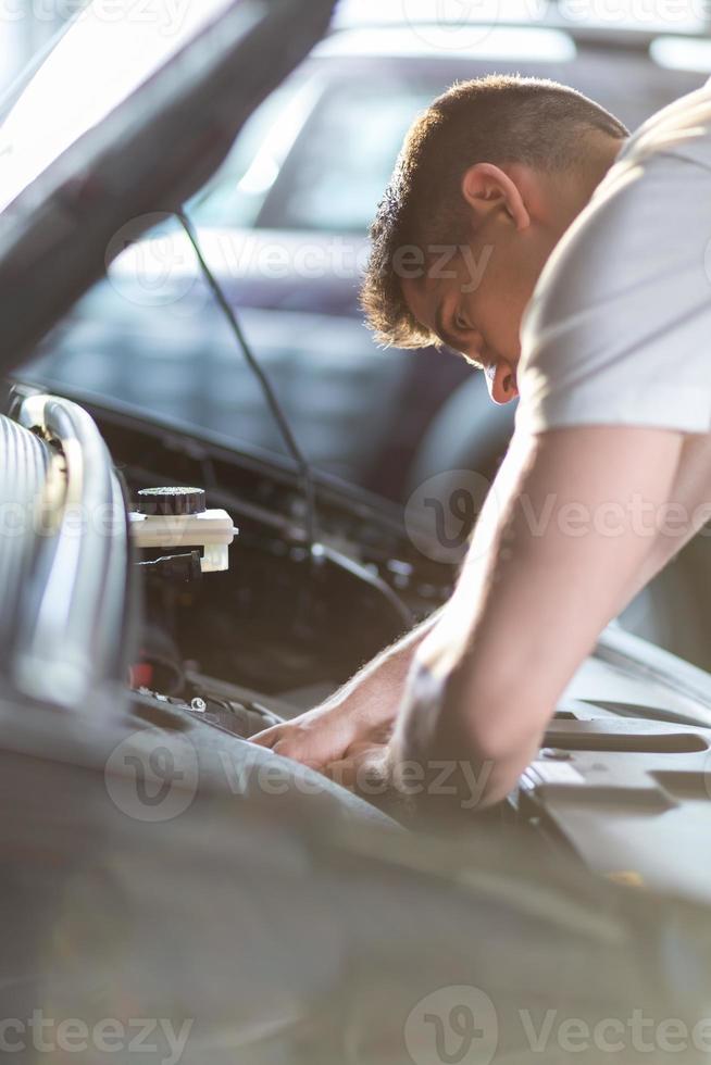 Automobile mechanic repairing a car photo