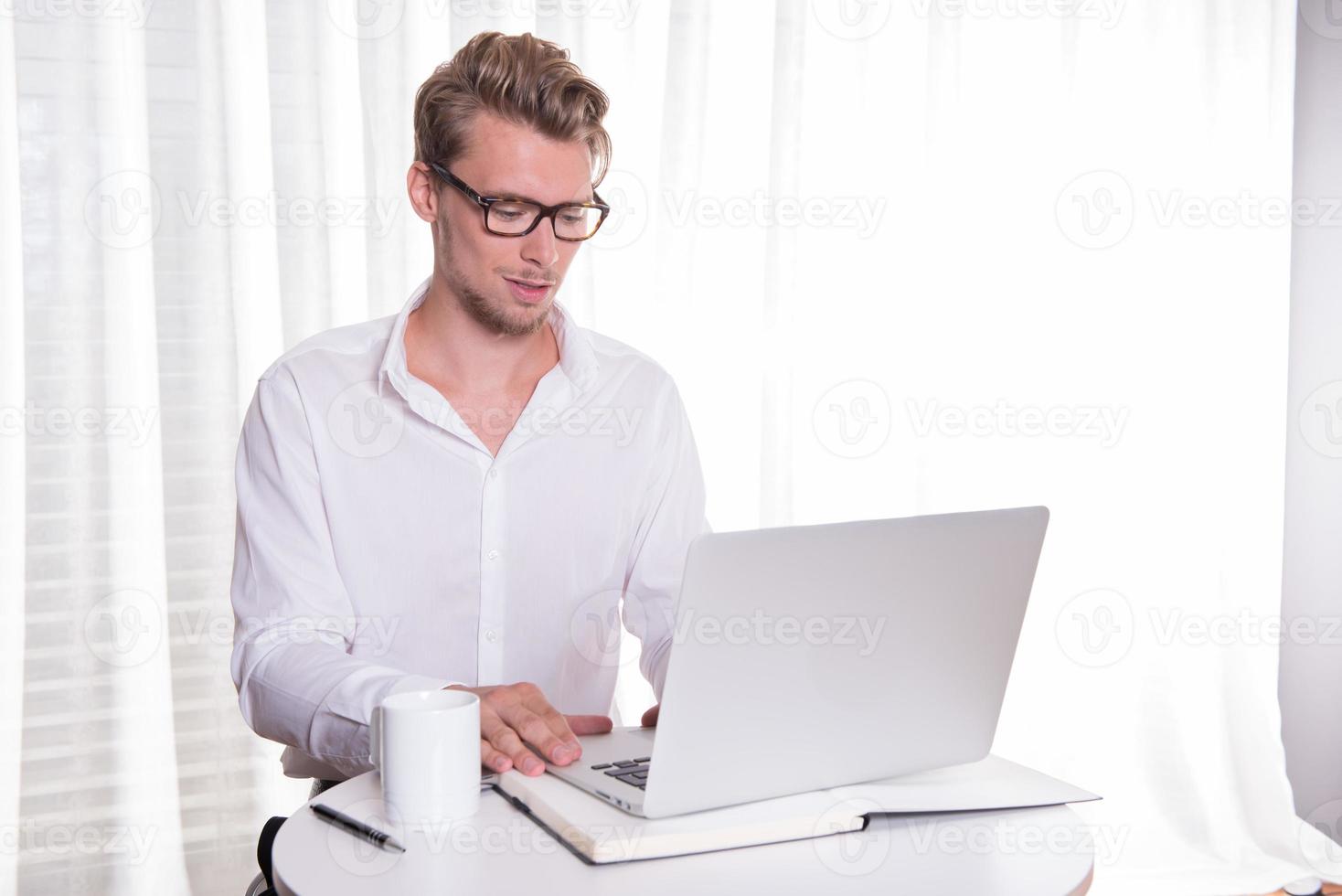 joven hombre de negocios trabajando en ordenador portátil foto