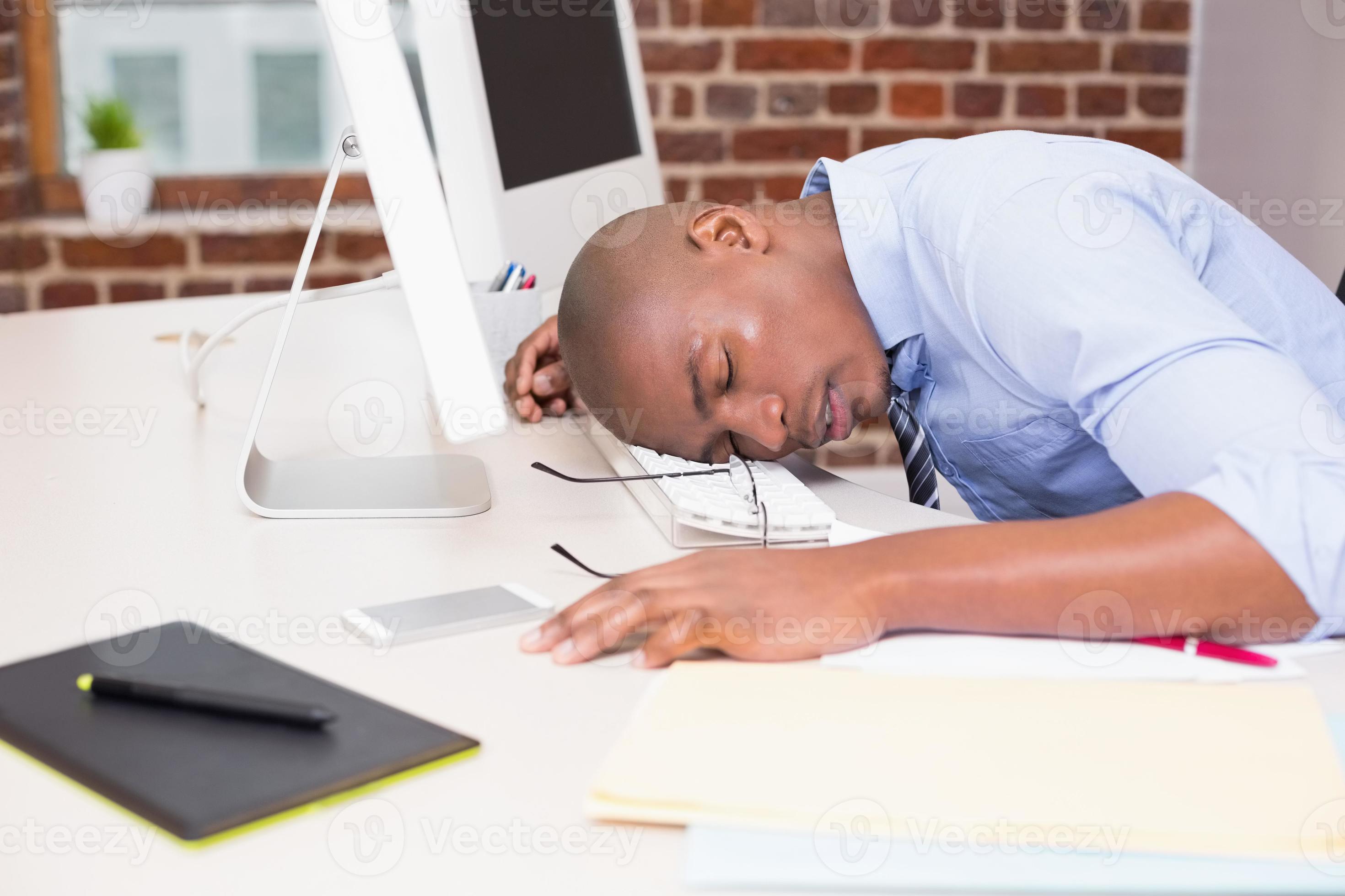 empresario descansando la cabeza sobre el teclado de la computadora foto