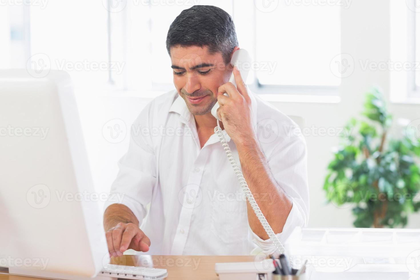 Businessman using telephone and computer photo