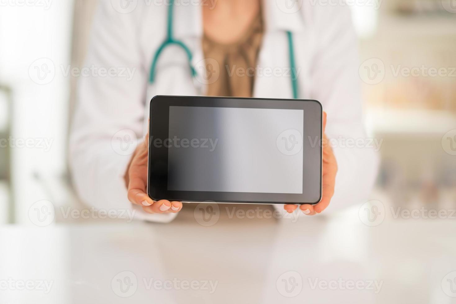 Primer plano de mujer médico mostrando tableta pc pantalla en blanco foto
