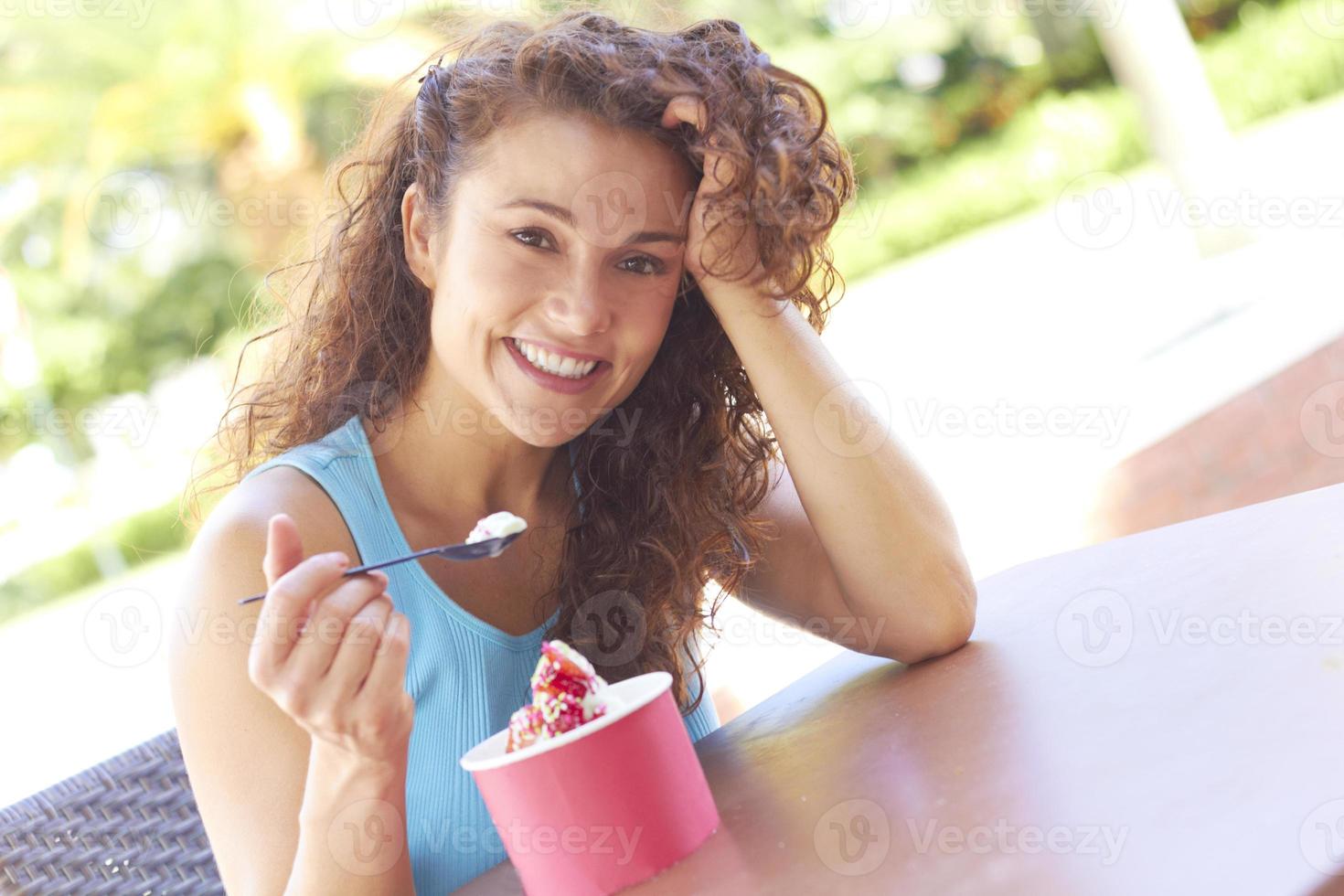 mujer joven disfrutando de yogurt congelado foto