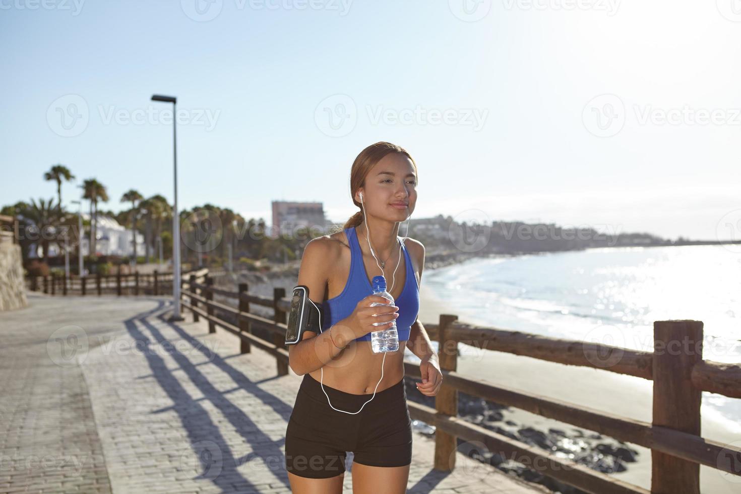 joven atleta corriendo en la orilla de la playa foto