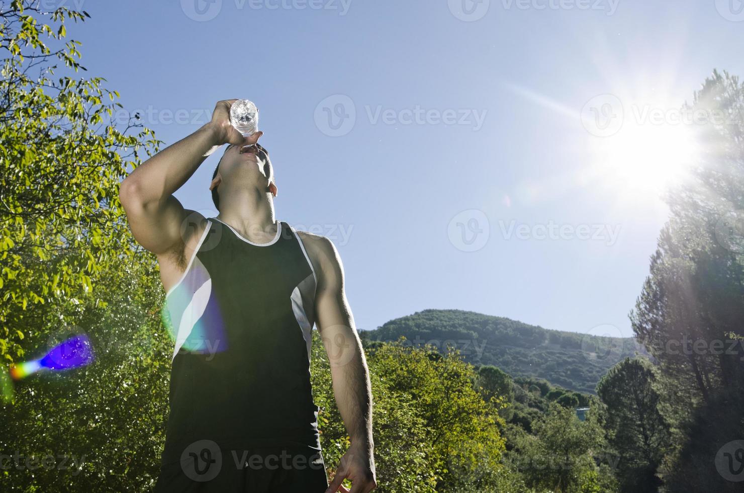 Sportsman drinking water with sunflare photo