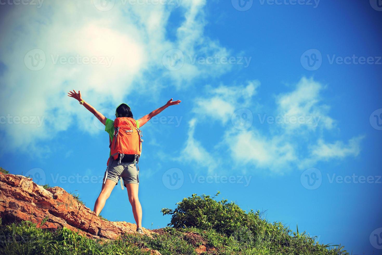 cheering young woman backpacker enjoy the view at mountain peak photo