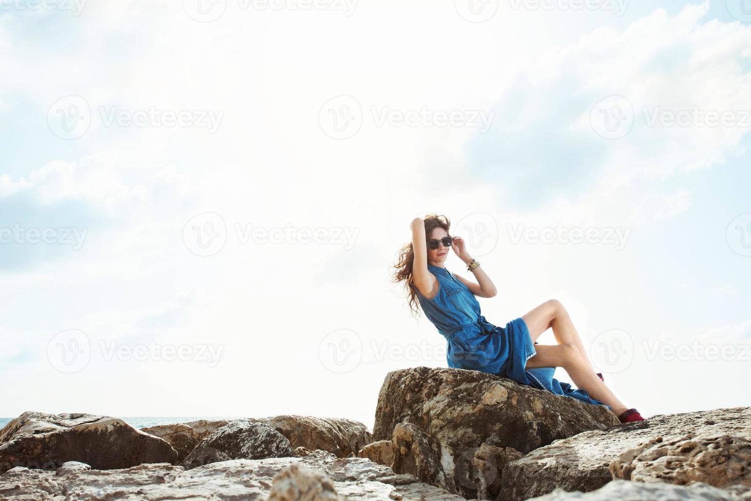 hermosa niña sentada en las rocas foto