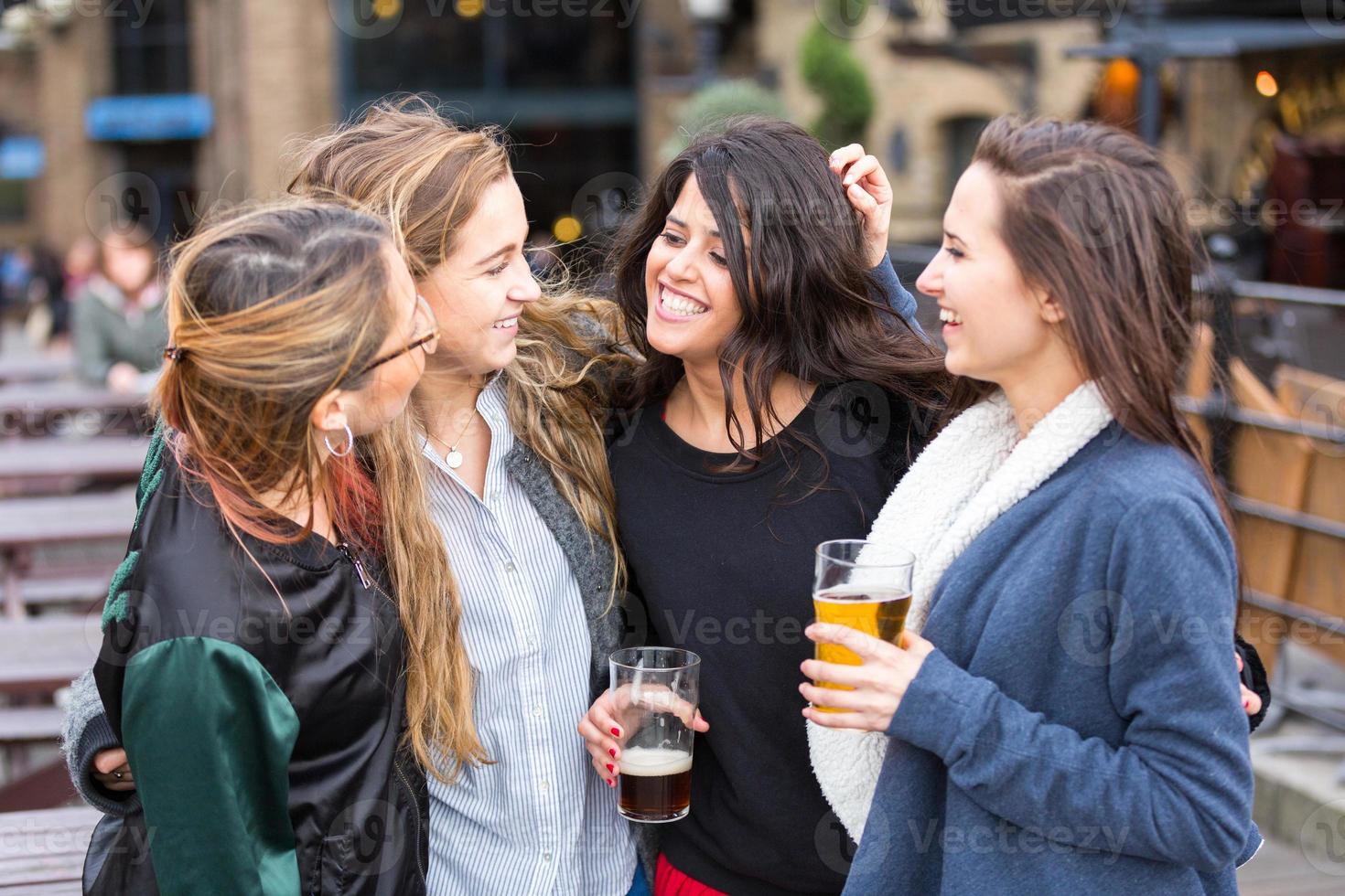 Grupo de mujeres disfrutando de una cerveza en el pub de Londres. foto