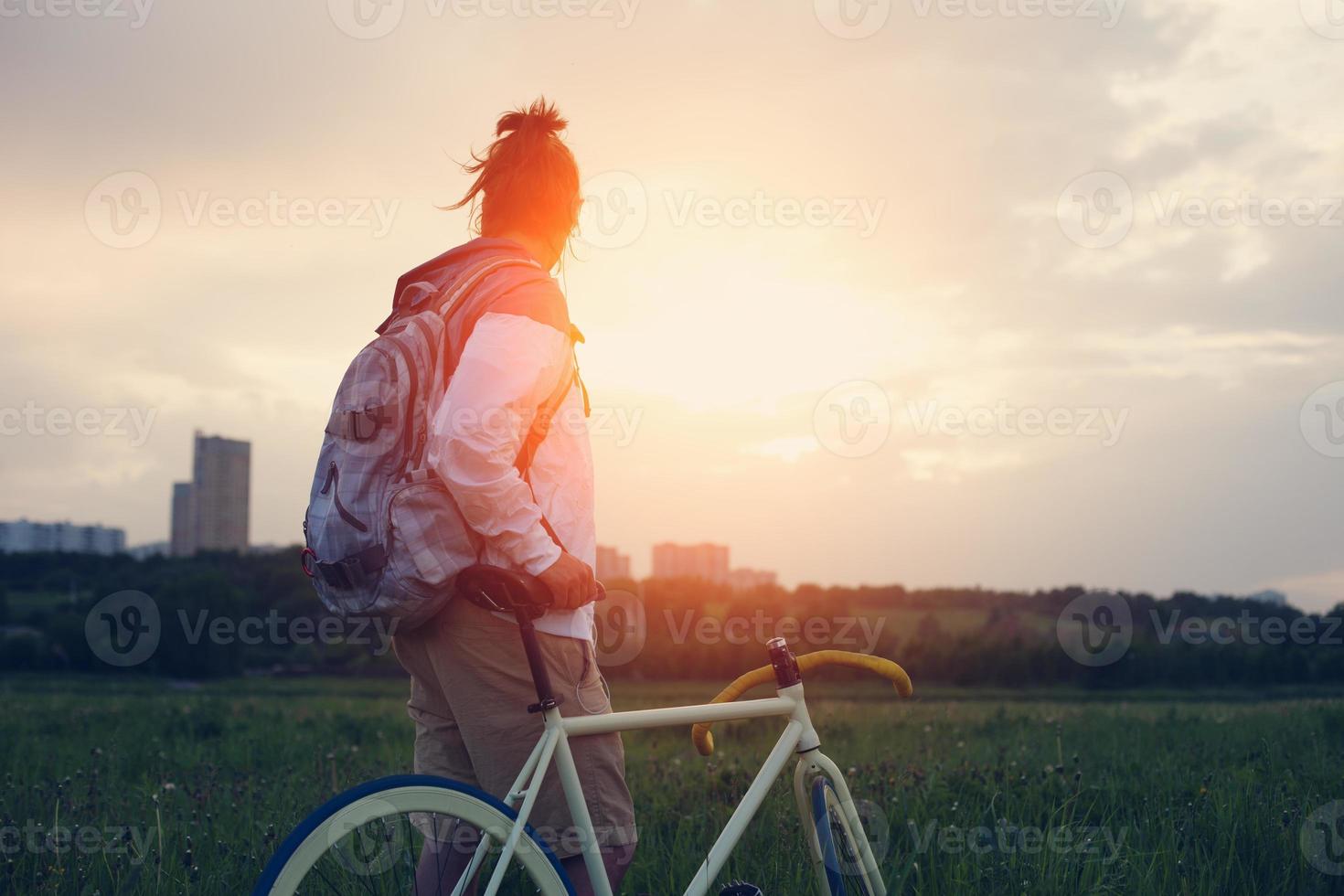 hombre con bicicleta en el campo verde foto