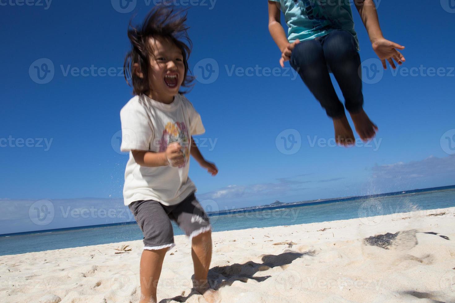 Children jumping on the beach photo