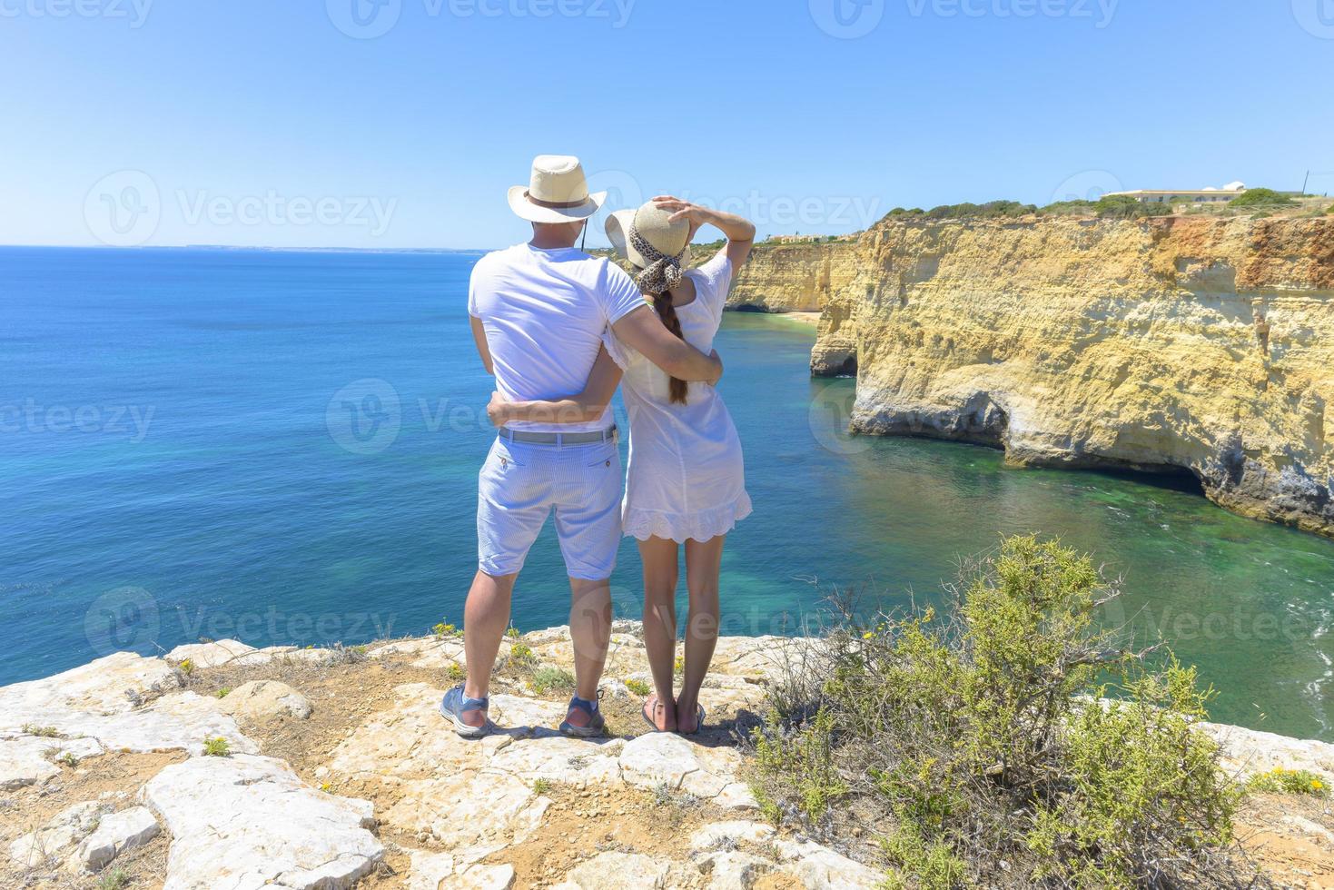 Couple enjoying the ocean view from a cliff photo