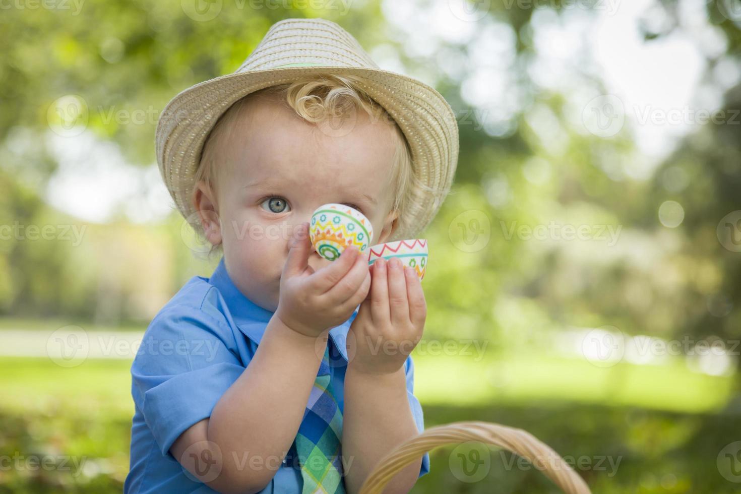lindo niño disfrutando de sus huevos de pascua afuera en el parque foto