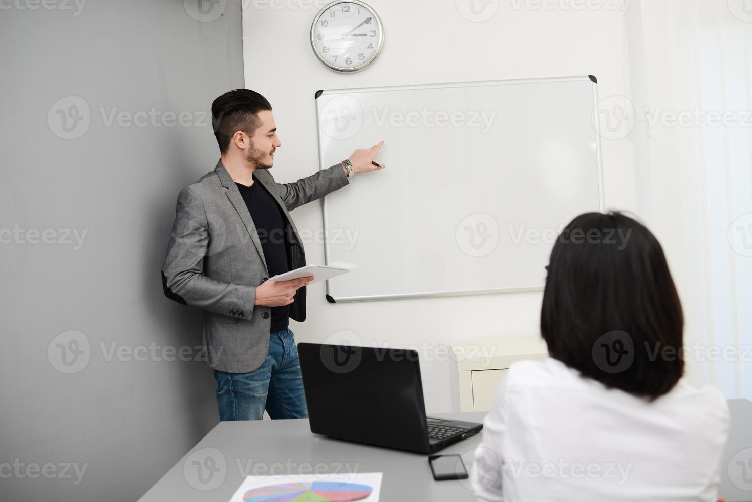 joven hombre de negocios o profesor mostrando datos en pizarra foto