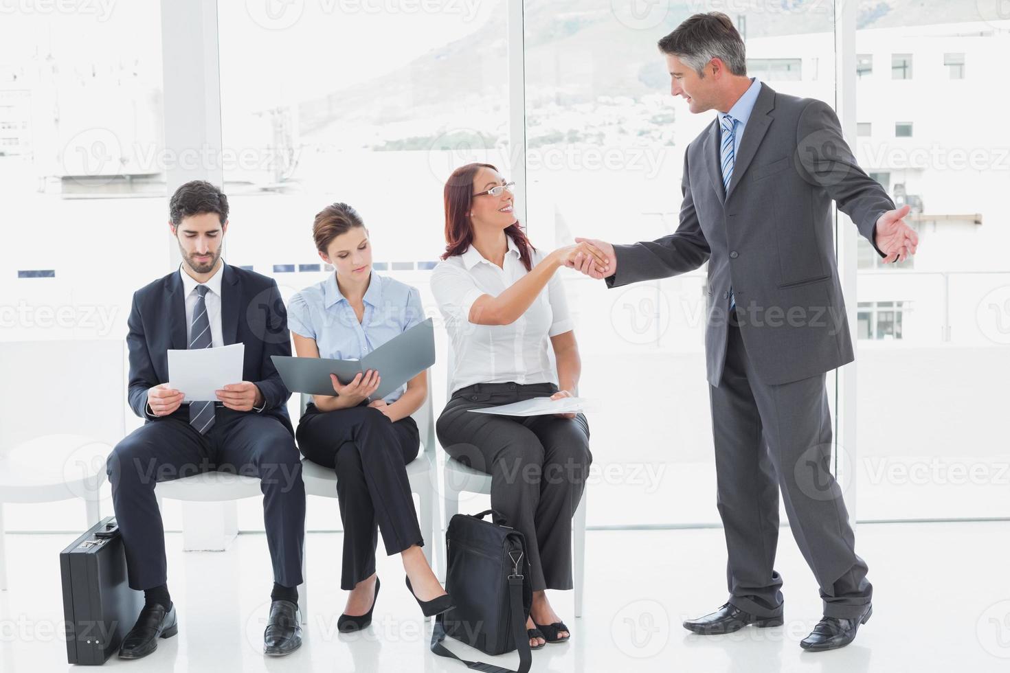 Smiling businessman shaking co-workers hand photo