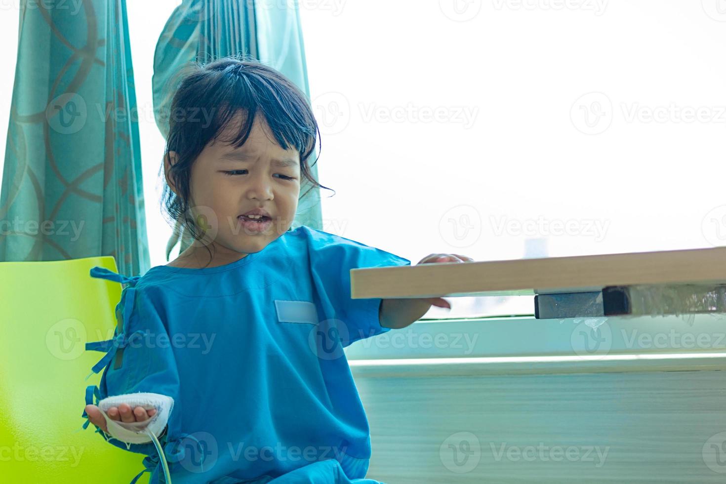 Illness asian kids sit on a chair in hospital photo