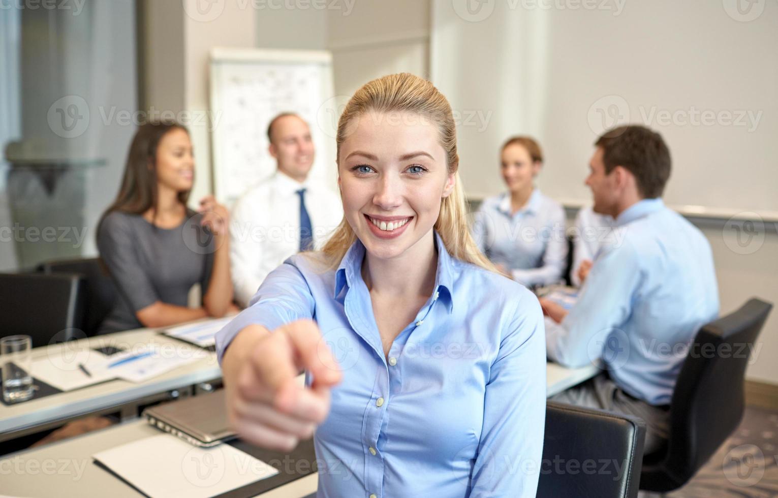 group of smiling businesspeople meeting in office photo