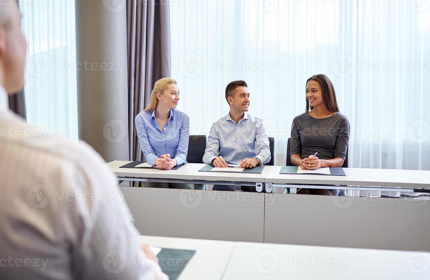 Grupo de empresarios sonrientes reunidos en la oficina foto