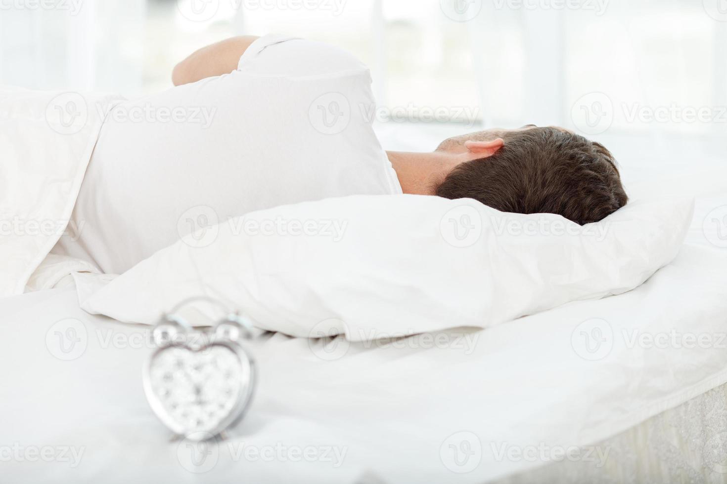 atractivo joven está durmiendo la siesta en la mañana foto