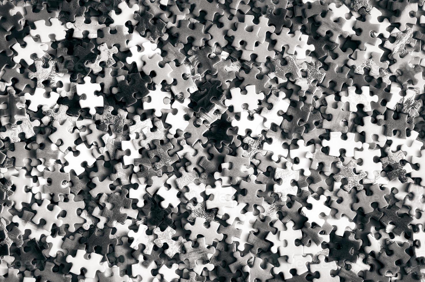 Pile of unfinished puzzle pieces in monochrome look photo