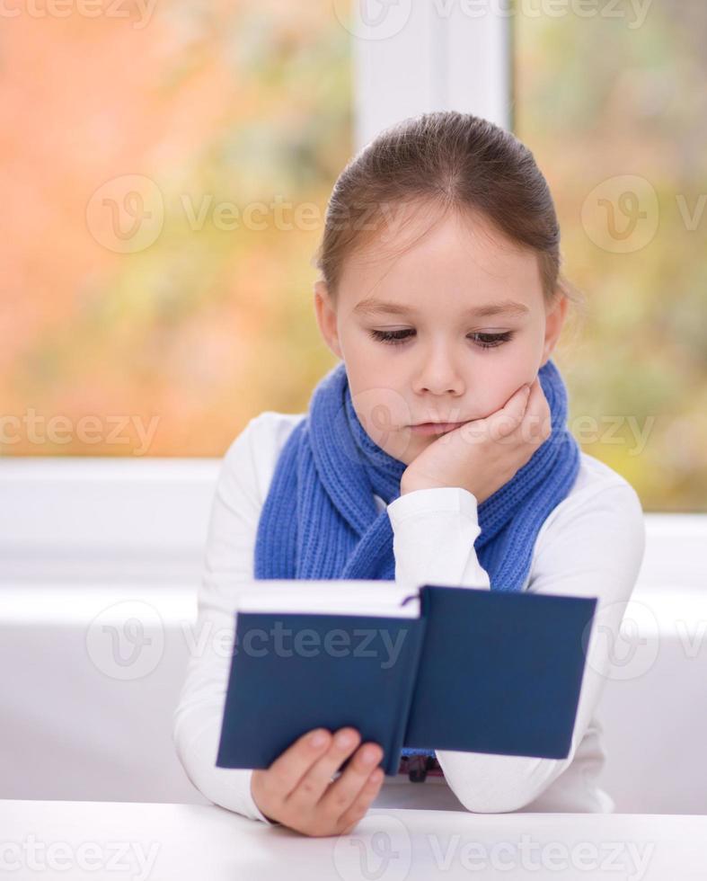 Little girl is reading a book photo
