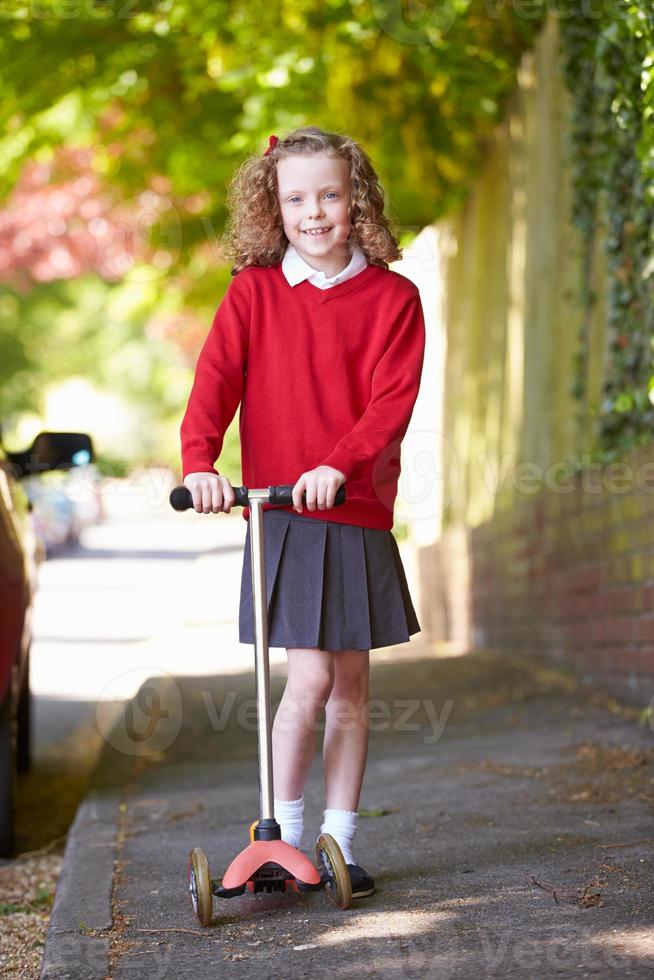 Chica montando scooter camino a la escuela foto
