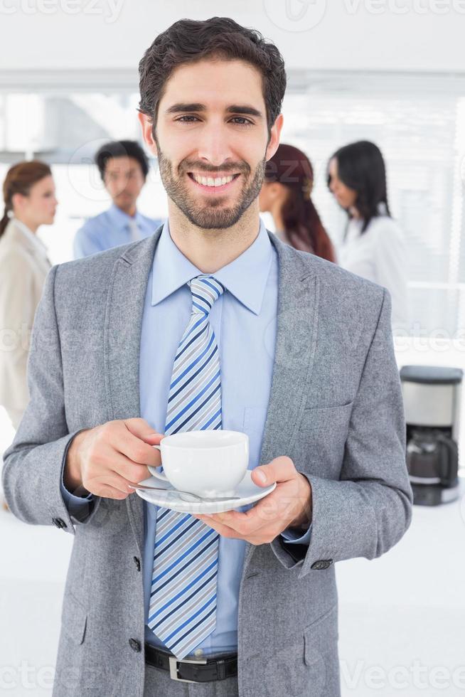 Smiling businessman with a drink photo