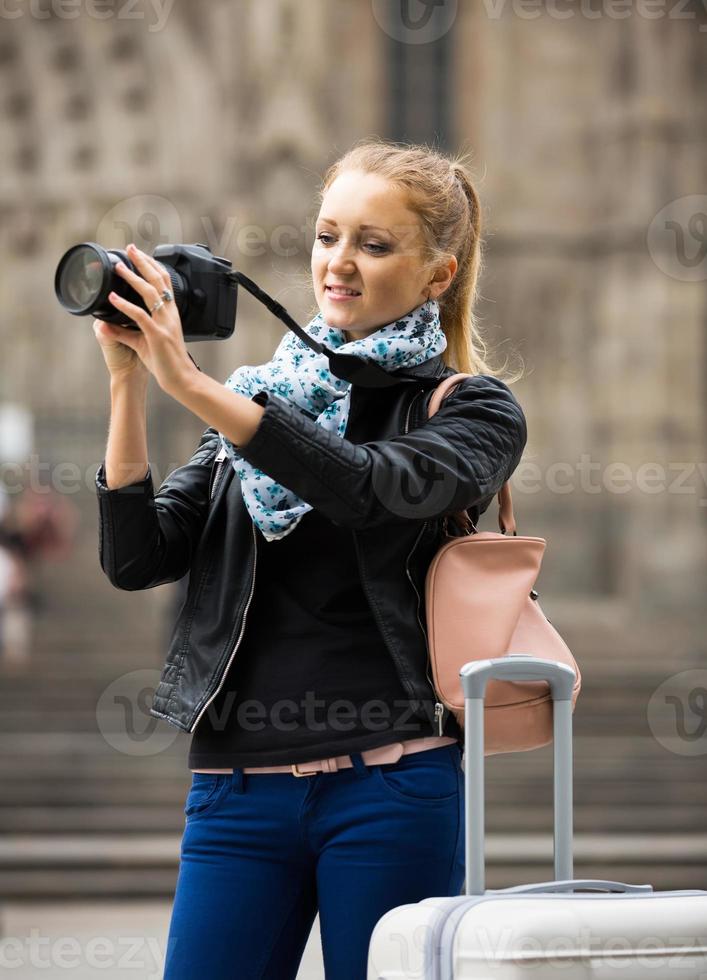 Mujer caminando en la ciudad de otoño con cámara digital foto