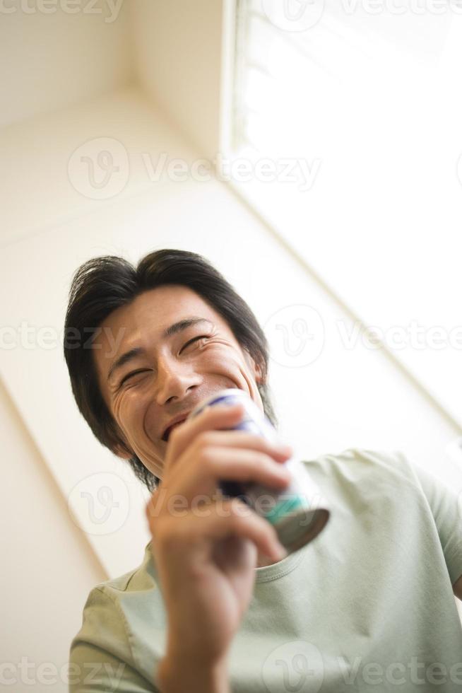 Man laughing with canned drink photo