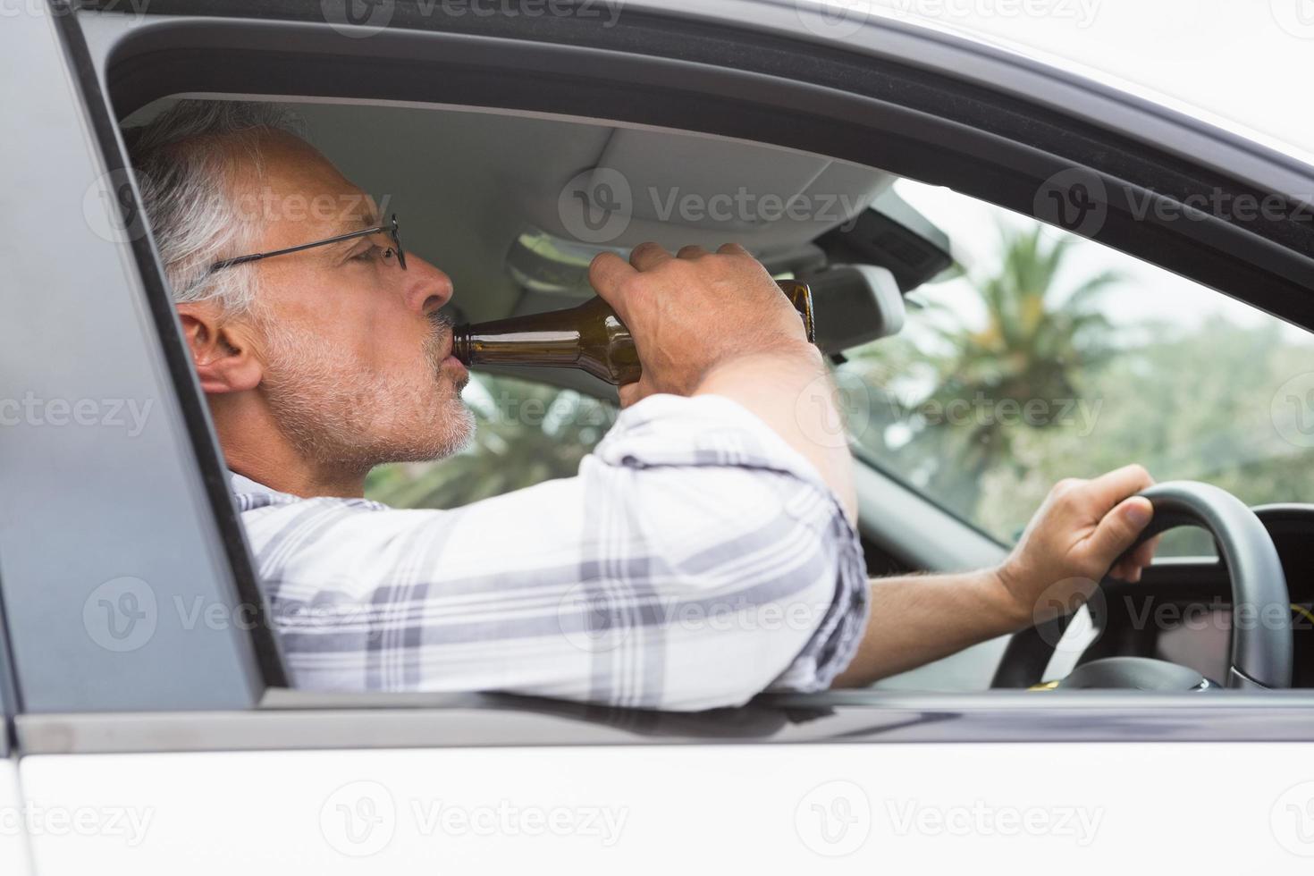 hombre bebiendo cerveza mientras conduce foto