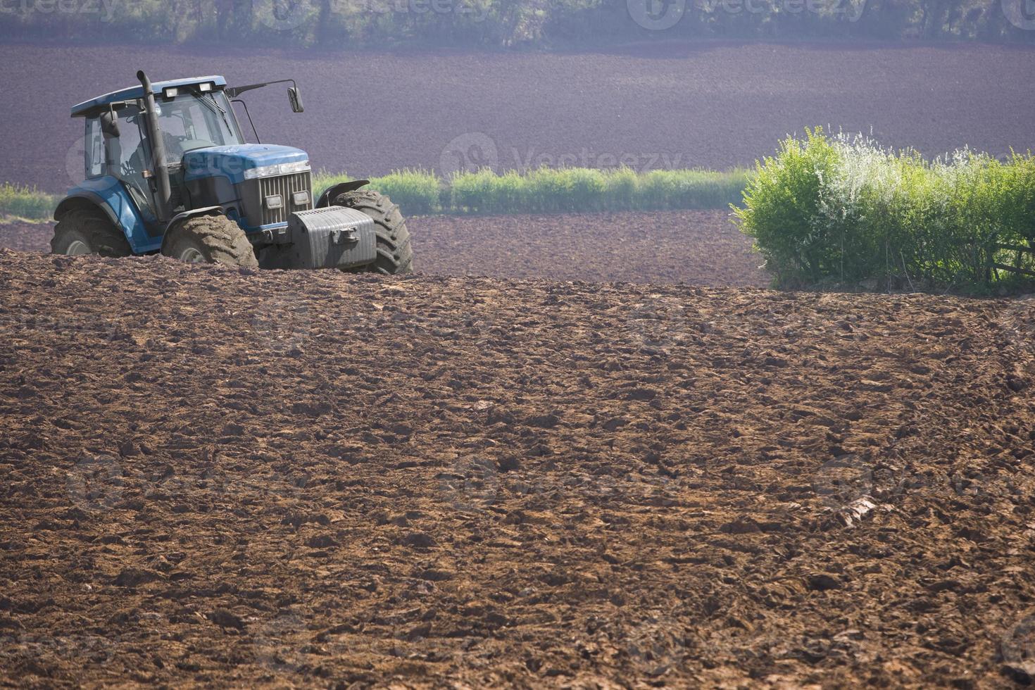 Tractor ploughing field photo
