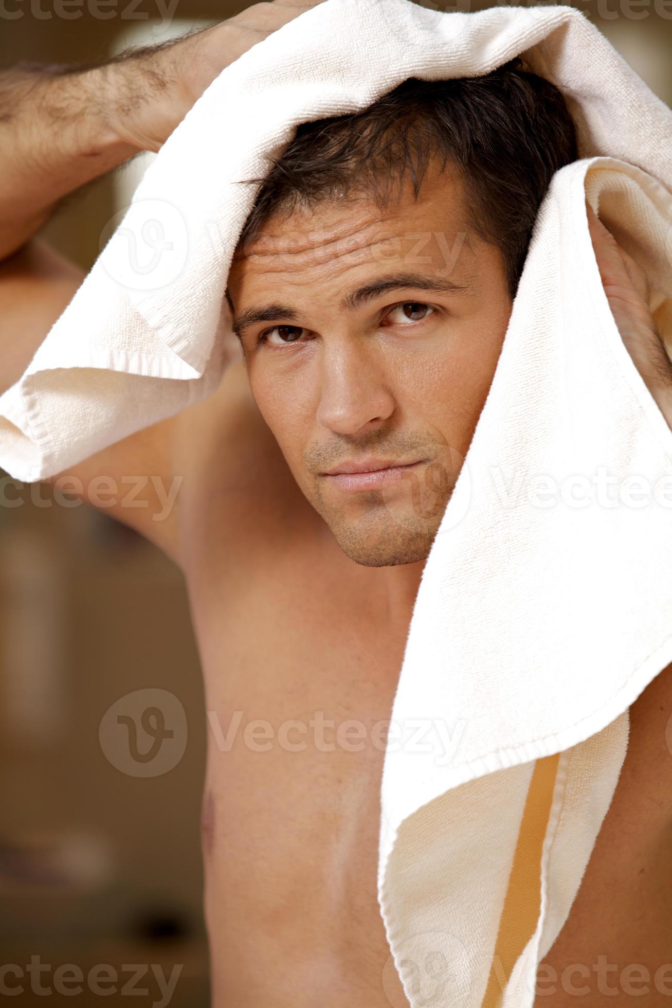 Portrait of young man drying hair with towel 942327 Stock Photo at Vecteezy