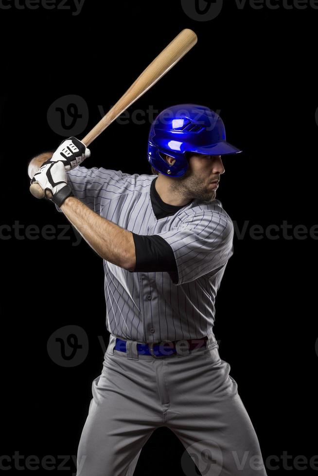Baseball player batting in gray stripe uniform & blue helmet photo