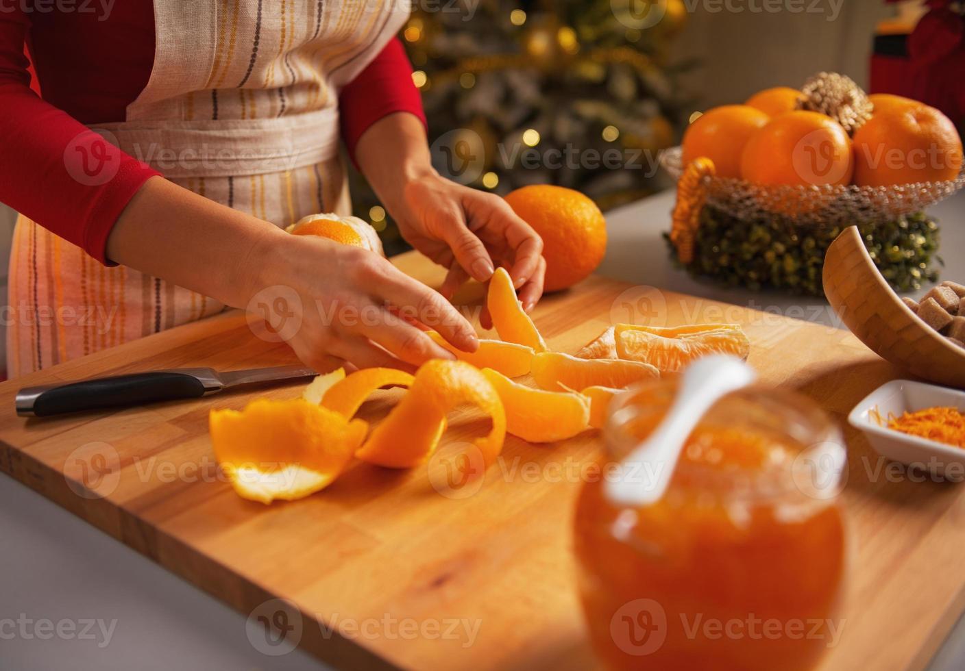 Primer plano de joven ama de casa haciendo mermelada de naranja foto