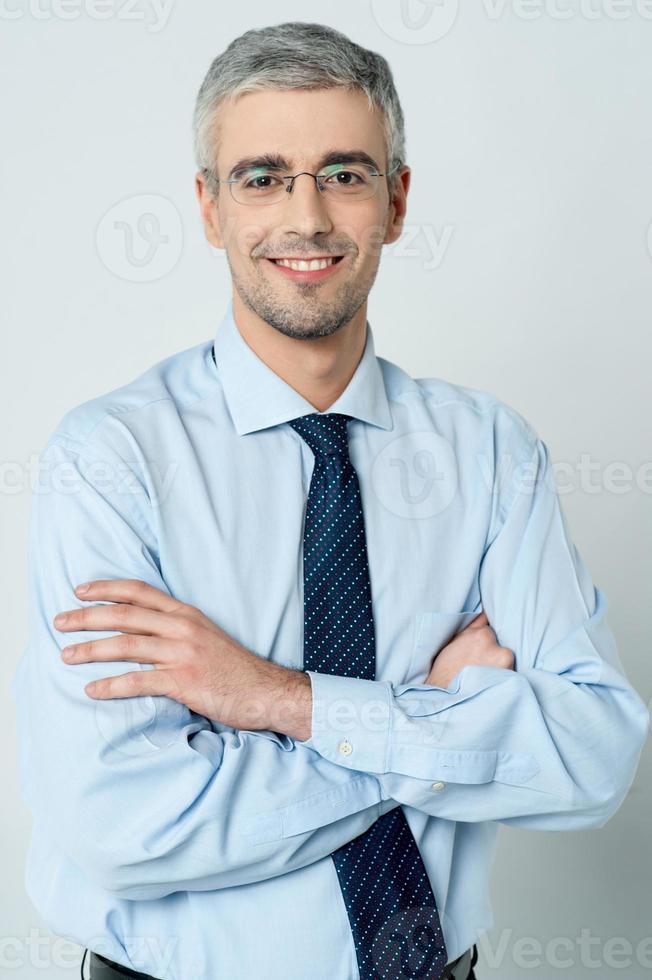 Cheerful businessman with arms folded photo