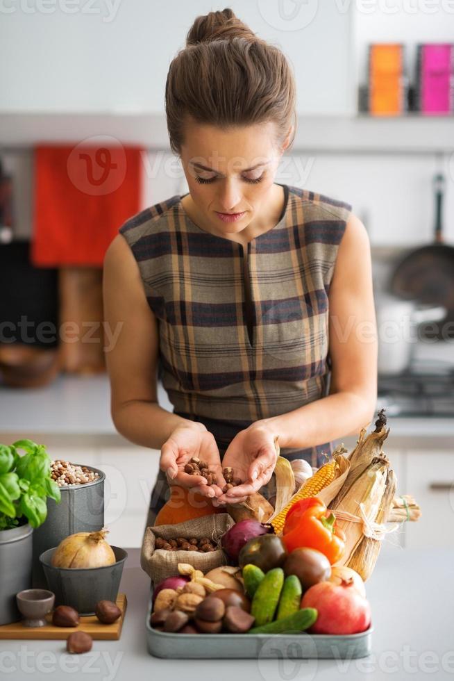 joven ama de casa con verduras en la cocina foto