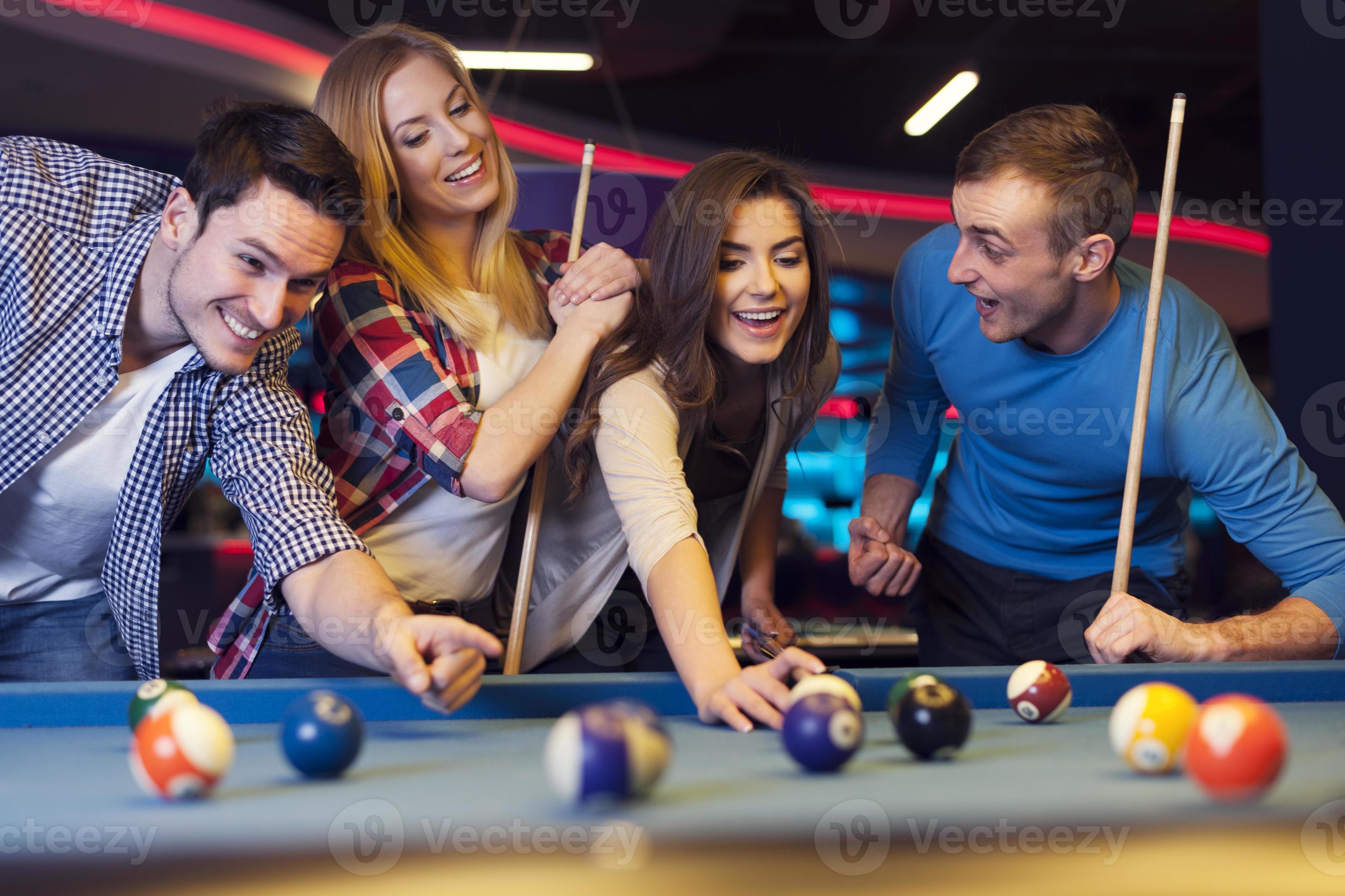 Group of young friends playing billiard 945174 Stock Photo at Vecteezy