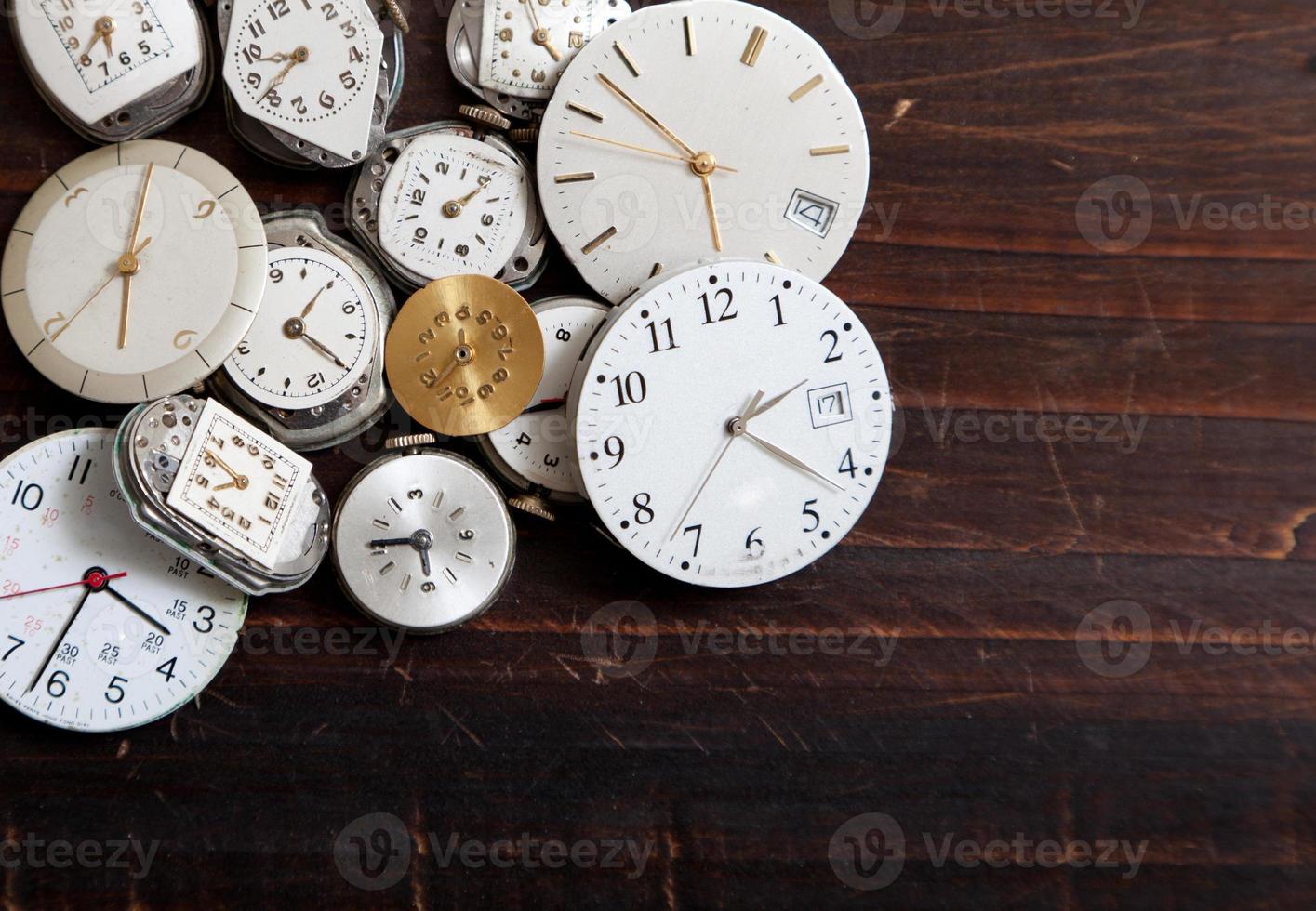 Large assortment of wrist watch faces on a wood background photo