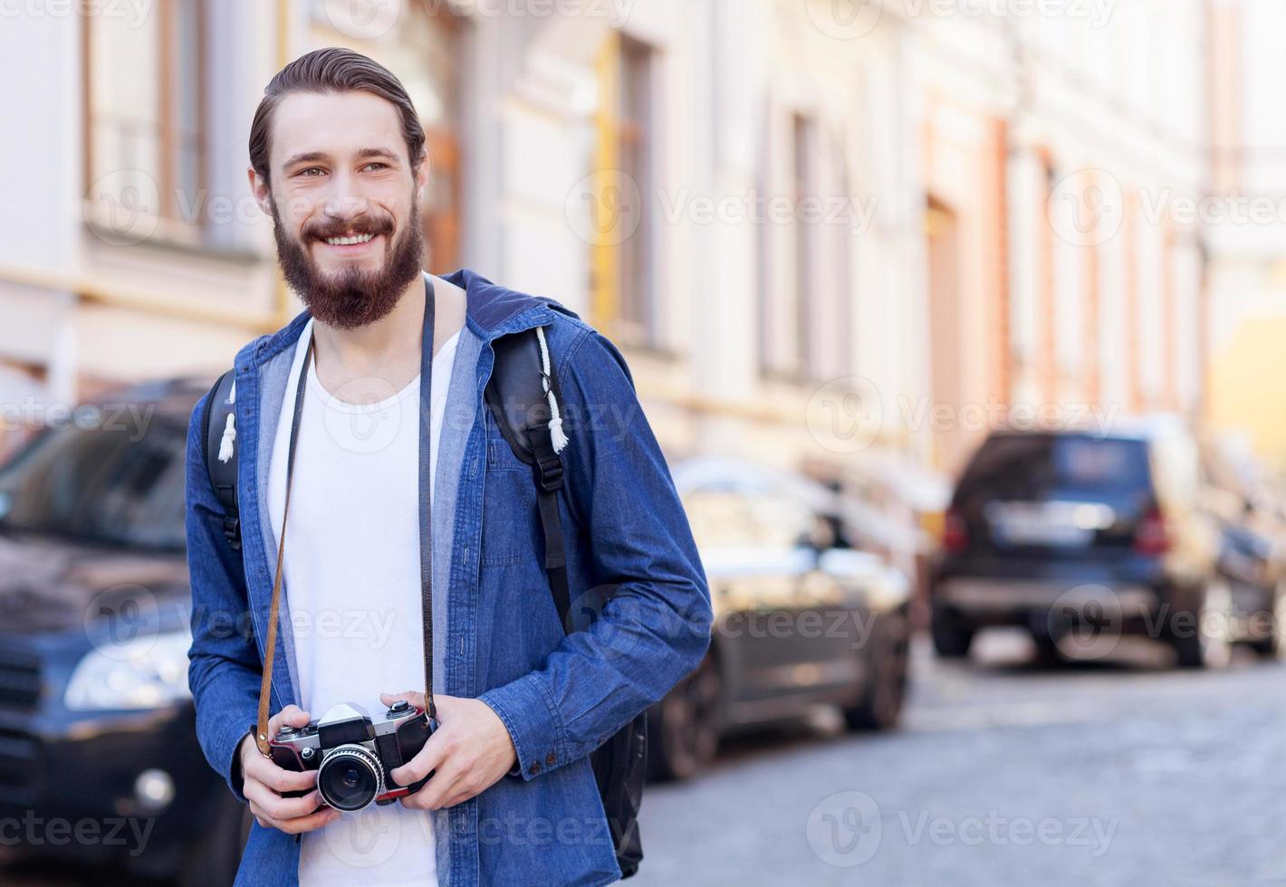 Cheerful bearded tourist is making his journey photo