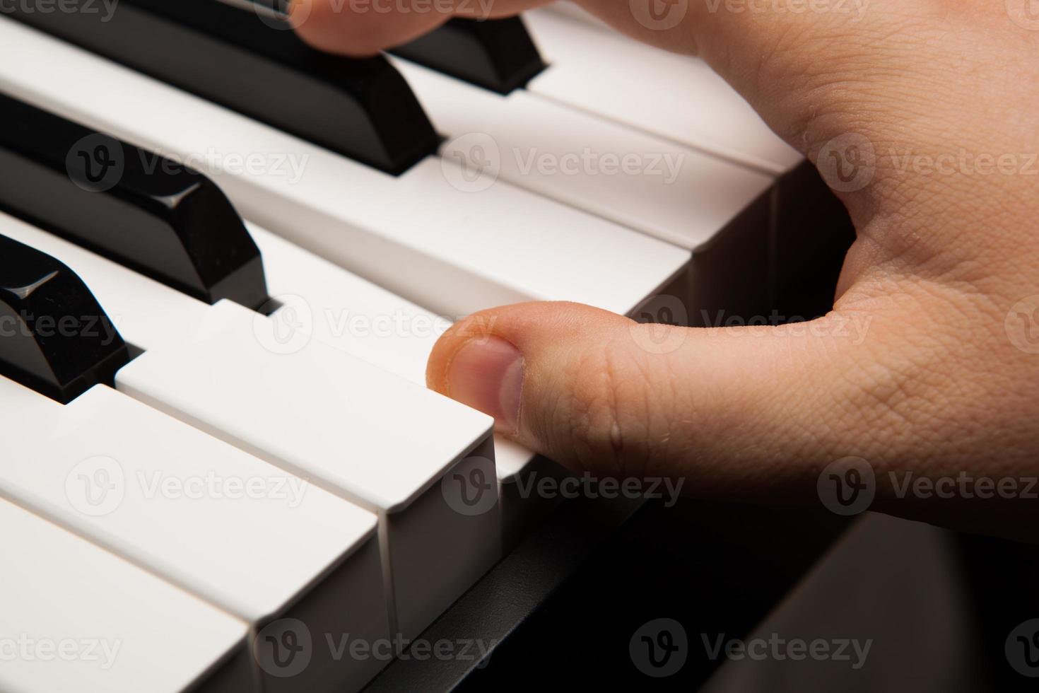 teclas de piano y dedo humano foto
