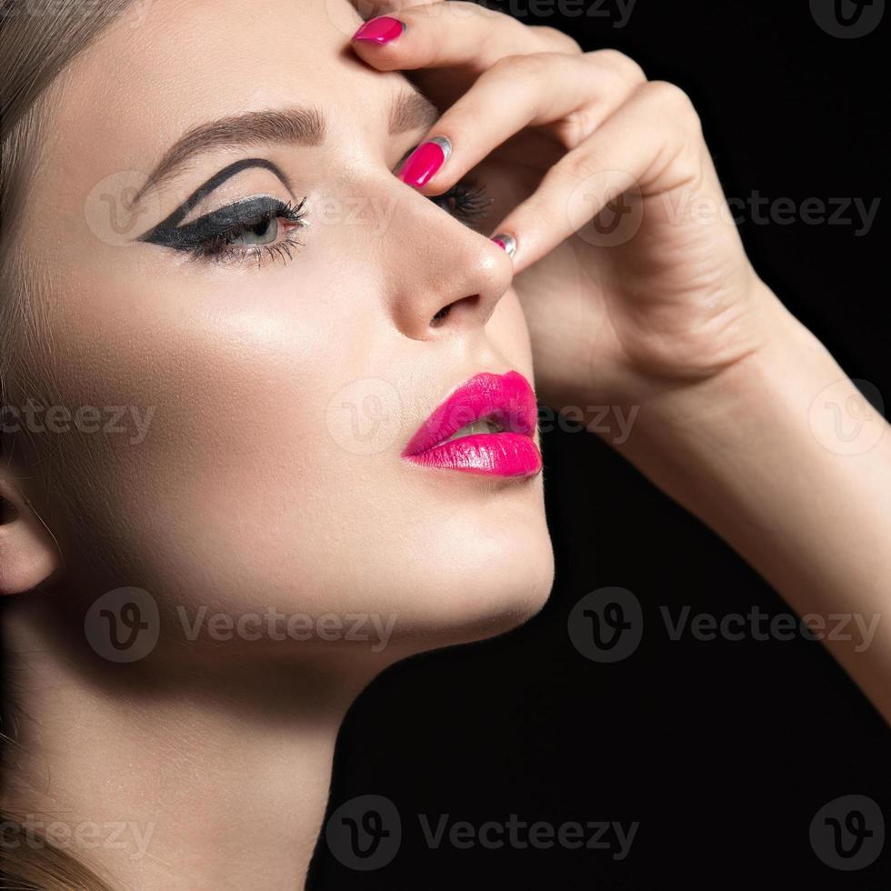 hermosa chica con flechas negras y uñas y labios rosados. foto