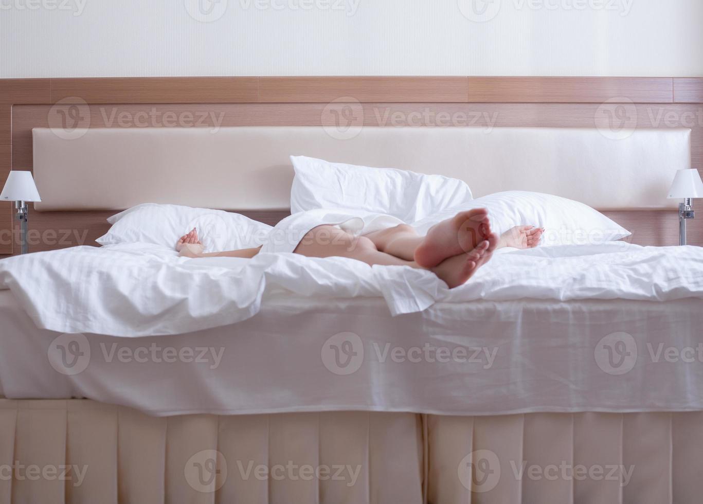 mujer joven relajarse en la cama - solo piernas foto