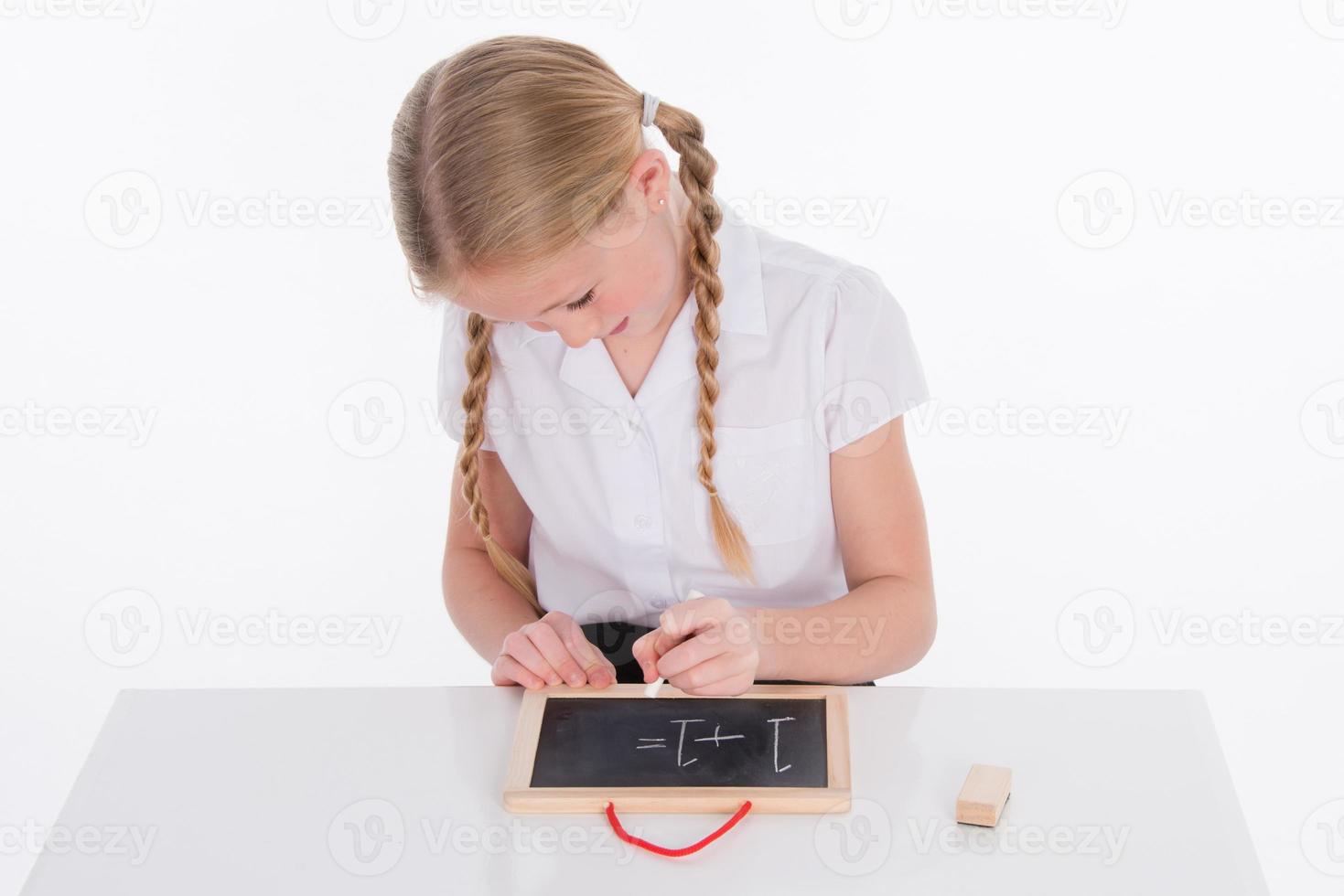 Young school writing on a chalkboard photo