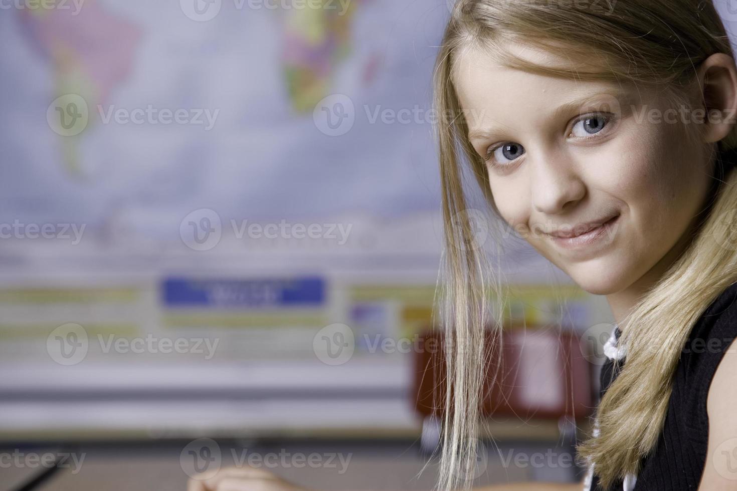 Young Girl Content at School Studying Geography photo
