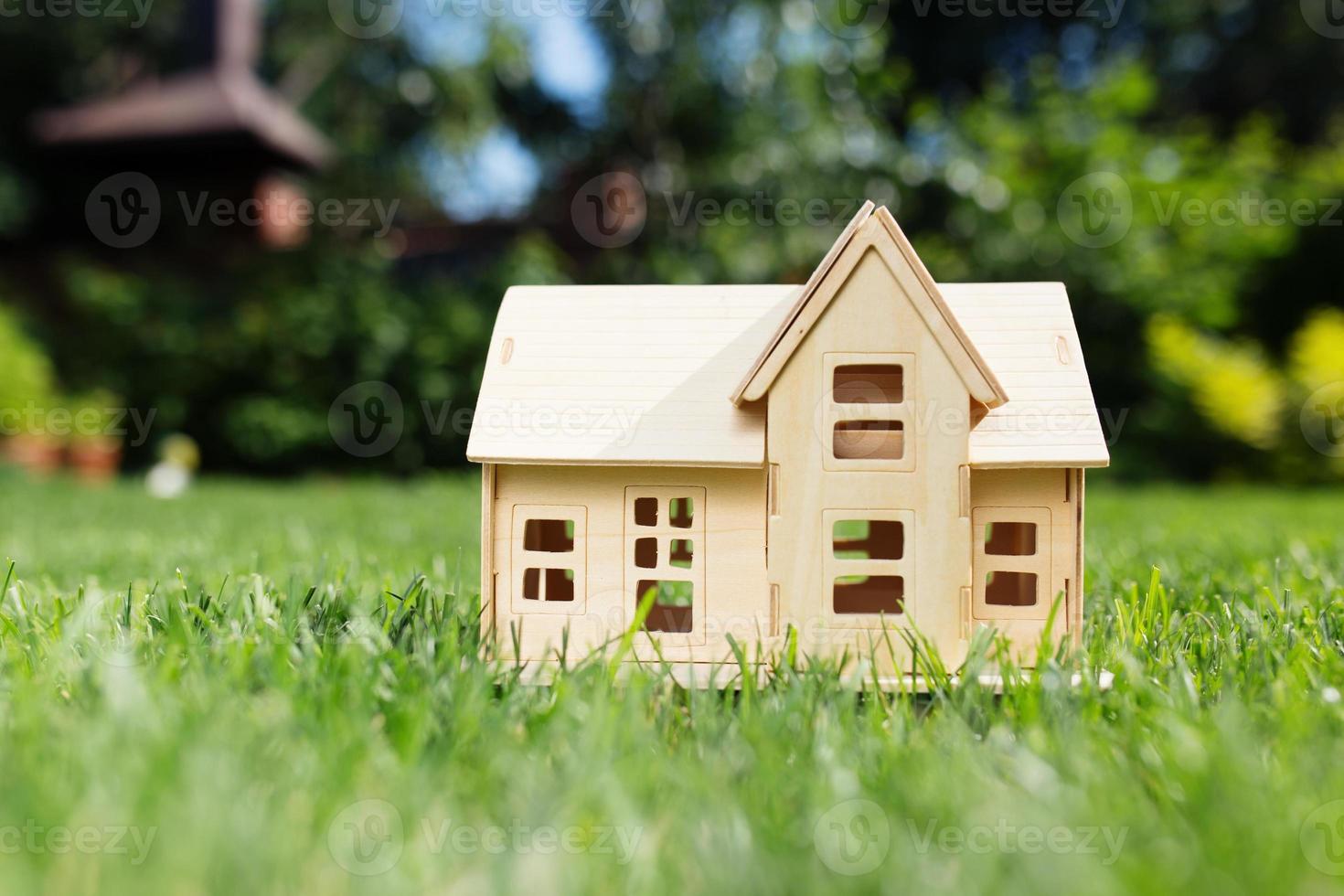 modelo de madera de la casa sobre césped, verano al aire libre, nuevo hogar foto