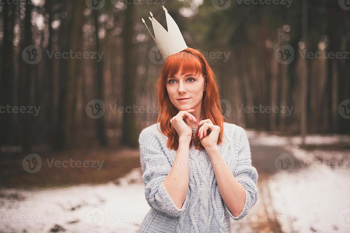 Mujer joven con corona en el bosque. foto