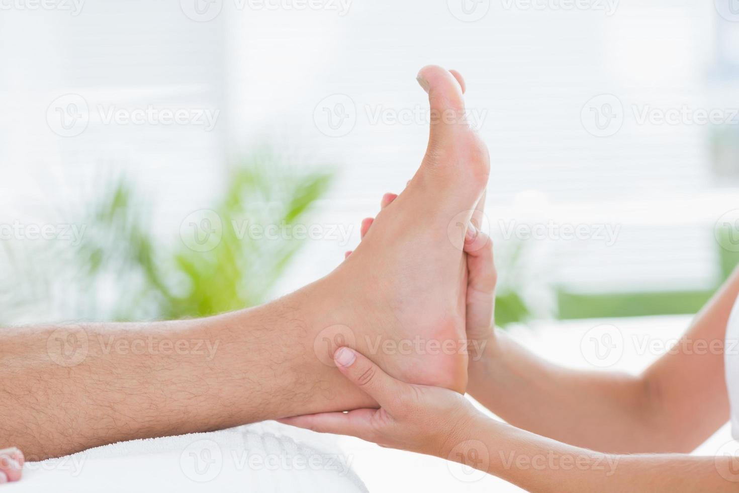 Physiotherapist doing foot massage photo