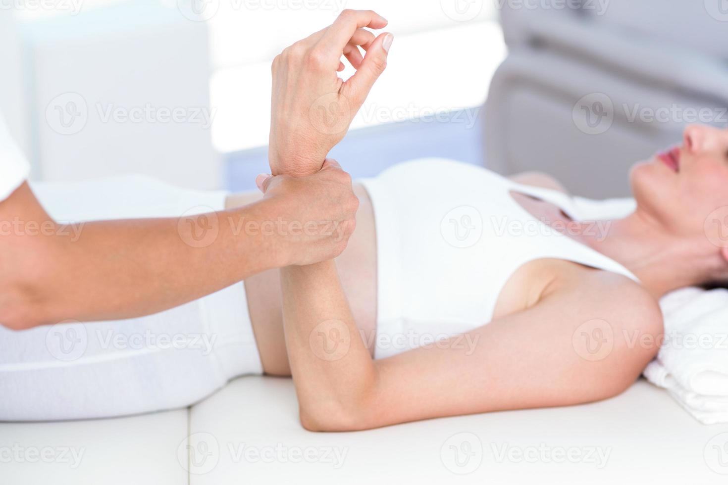 Physiotherapist examining her patients wrist photo
