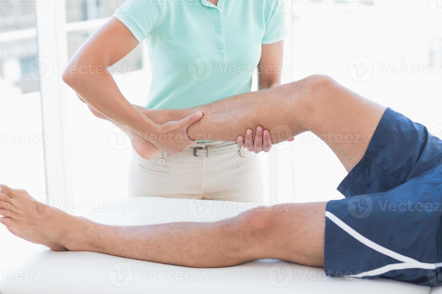 Doctor examining man leg photo